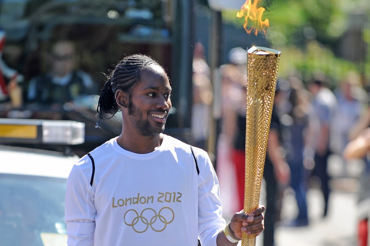 A man carries an Olympic torch.