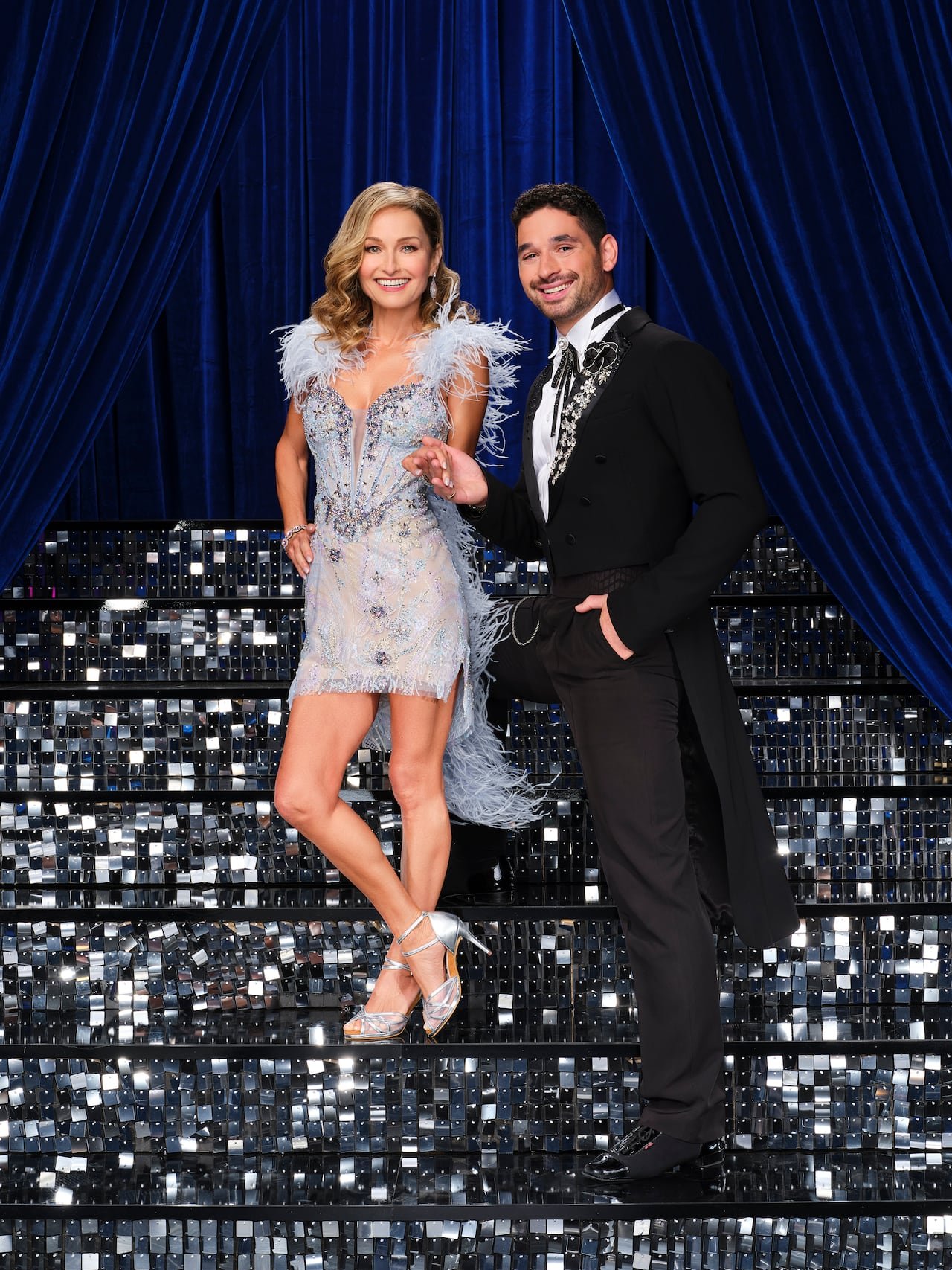 default-211 Woman in blue sparkly outfit holding hands with a man in a long black tuxedo on disco sequin stairs