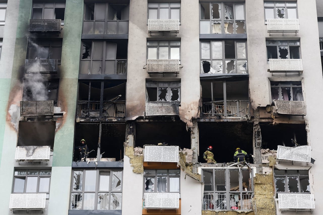 default-1372 Firefighters work at the site of a damaged apartment building.